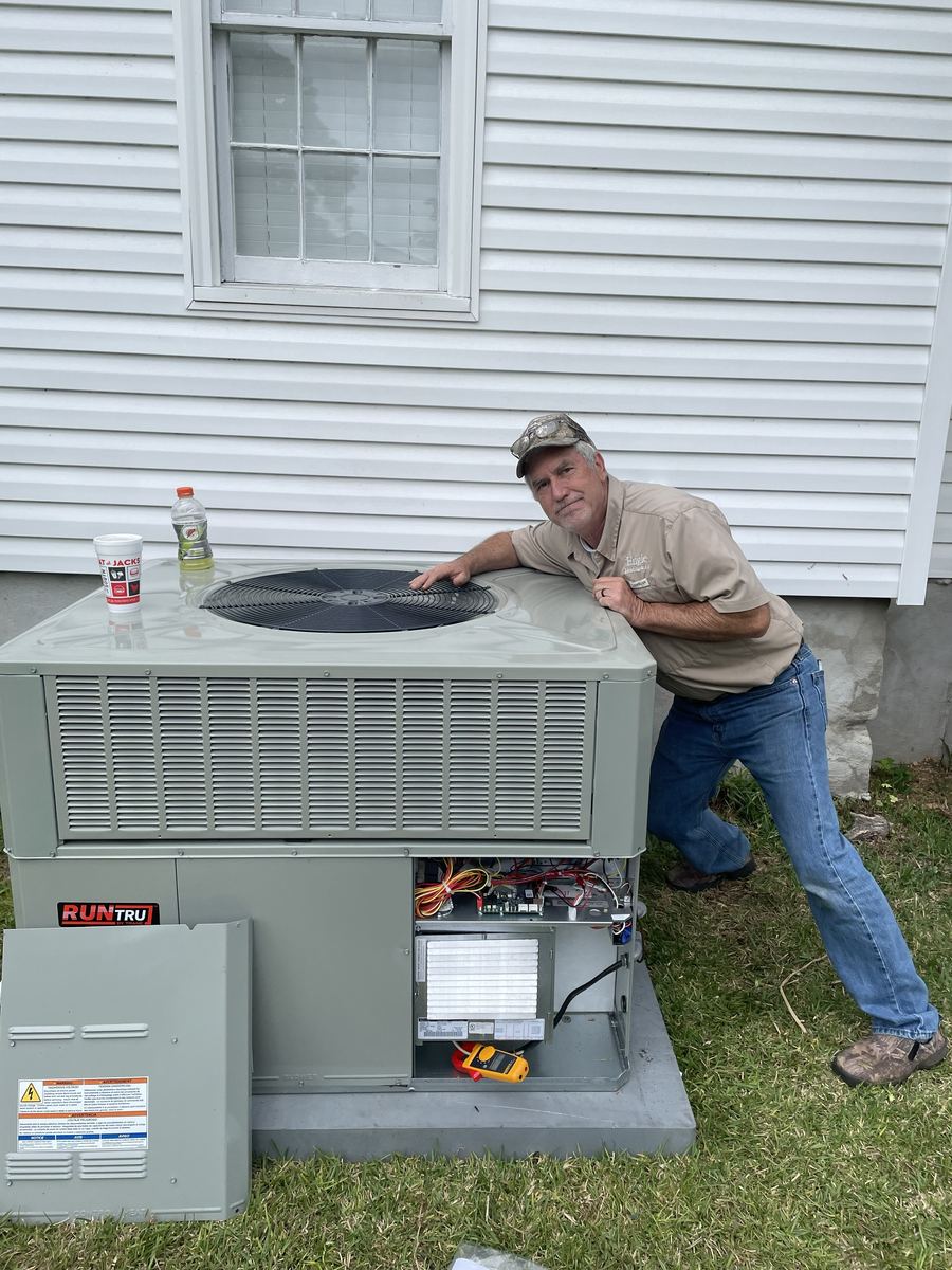 Allen Engle, owner of Engle Heating & Air, working on an outdoor AC unit in Houston County, GA