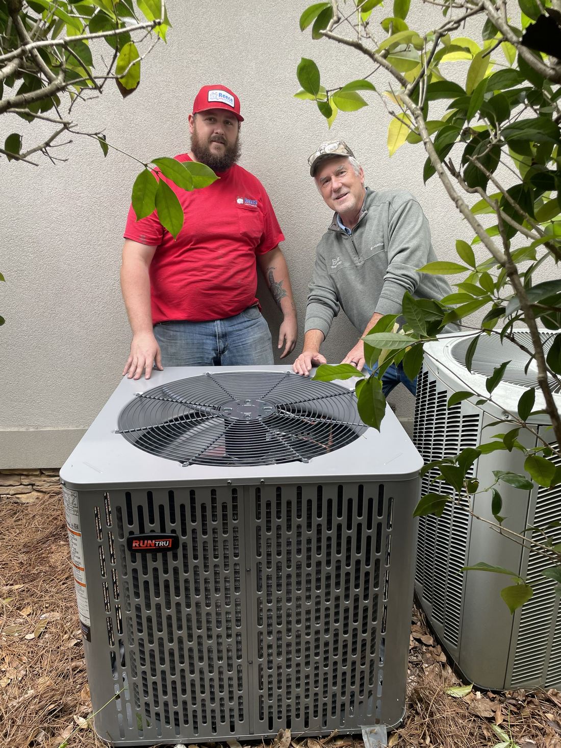 Allen Engle with a fellow technician beside two outdoor AC condenser units
